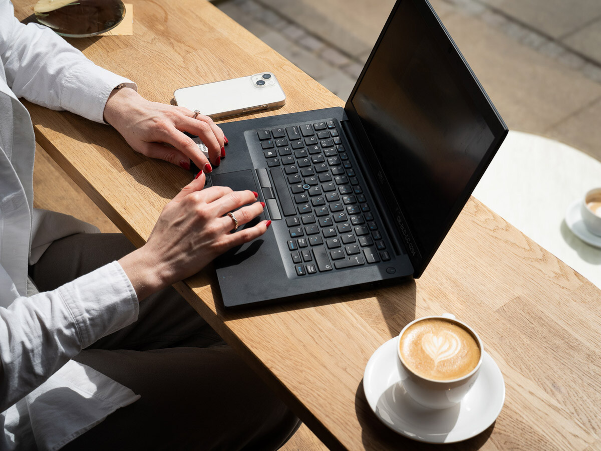 Medarbejder arbejder fra café med sin computer